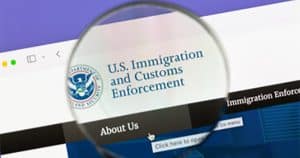Magnifying glass looking at Immigration and Customs Enforcement logo